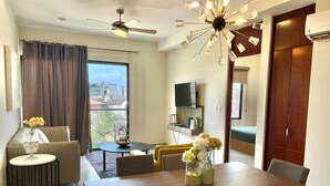 A modern living room with a dining table, sofa, and TV. - Steps from the beach in the Golden Zone (Mazatlán)