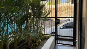 Un cancello chiuso con un'auto parcheggiata all'esterno, immerso nel verde.