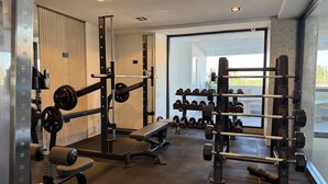 Ein Fitnessraum mit Gewichten, Bänken und Kurzhanteln.