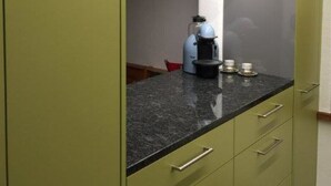 Een keuken met een koffiezetapparaat, een magnetron en een spoelbak.
