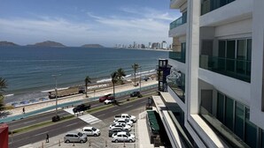 A modern building with a view of the ocean and a beach. - Departamento Premium Torre M by GPS (Mazatlán)