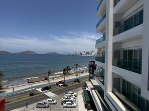 A modern building with a view of the ocean and a beach. - Departamento Premium Torre M by GPS (Mazatlán)