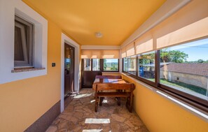 A corridor with a stone floor, a wooden bench, and a view of the outside through large windows. - Awesome home in Pazin (Pazin)