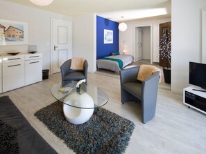 A modern living room with a glass coffee table, two armchairs, a sofa, and a television on a stand. - Chasa Diala, (Scuol) by Interhome (Scuol)