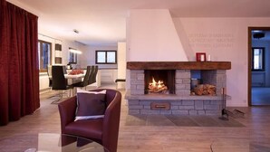 Una sala de estar moderna con chimenea, comedor y vistas al exterior.