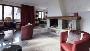 Una sala moderna con chimenea, un sofá, una silla y un comedor al fondo.