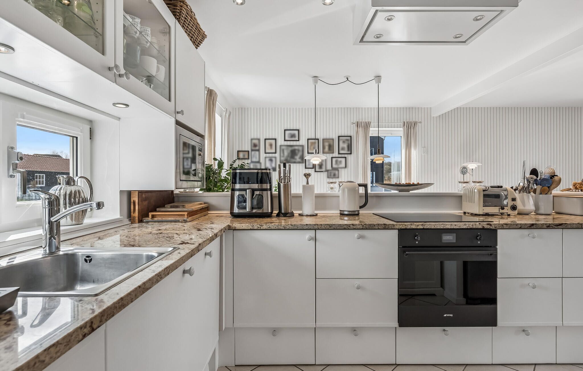 Una cucina moderna con lavastoviglie integrata, elettrodomestici in acciaio inossidabile e un'ampia finestra con vista.