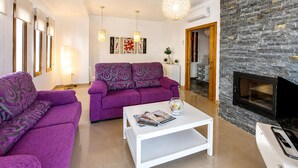 Un salon avec un canapé, une table basse et une cheminée.