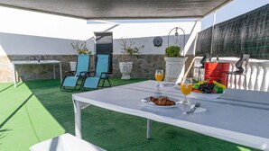 An outdoor dining area with a table set for two, chairs, a fruit bowl, and a dartboard. - Lovely home in Pechina (Pechina)