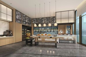 Una cocina moderna con una isla central, una cafetera y un chef preparando comida.