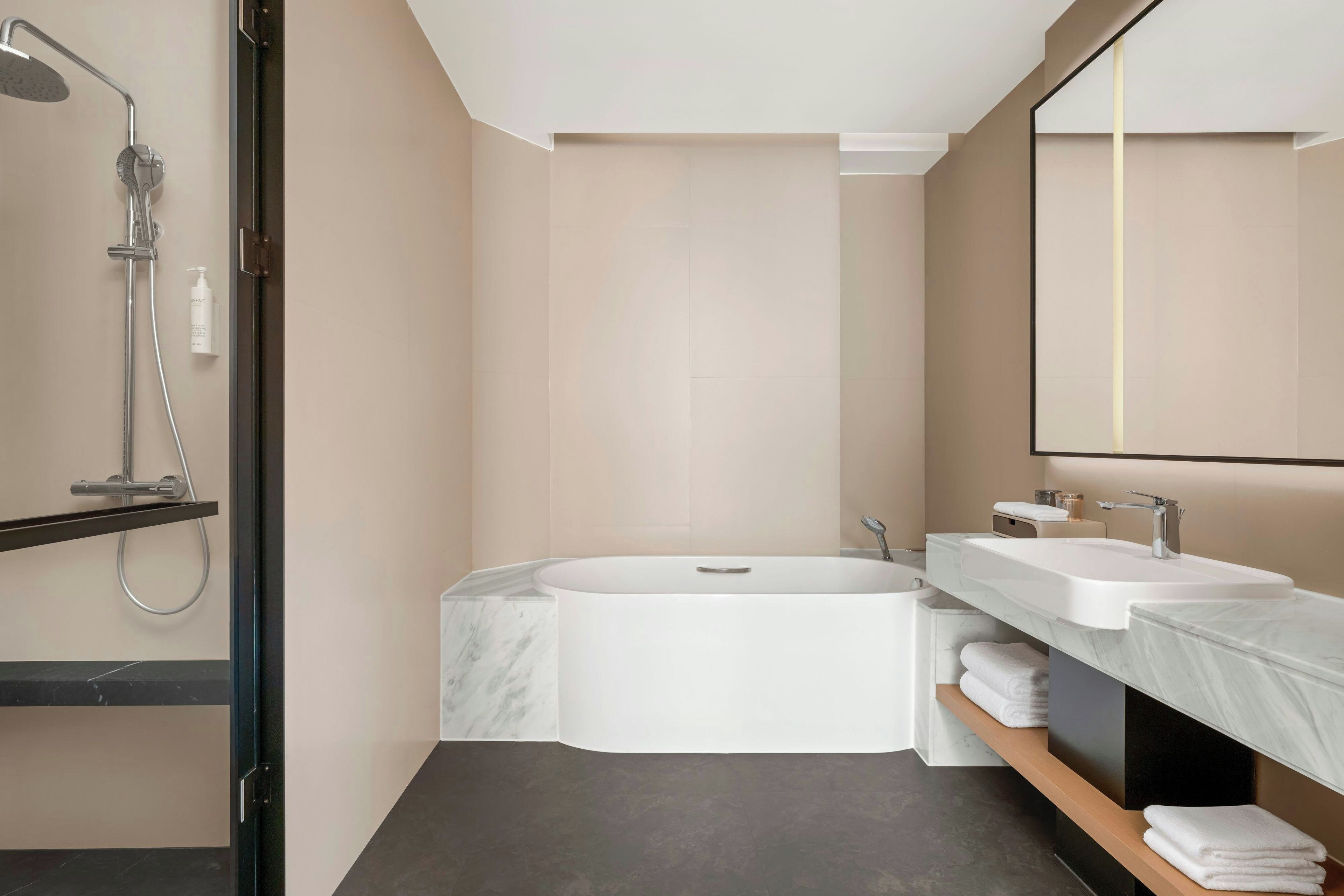 A modern bathroom with a freestanding bathtub, a showerhead, and a vanity with a mirror.