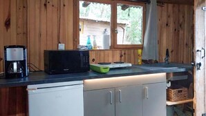 Una cucina con forno a microonde, macchina del caffè e una finestra vista esterna.