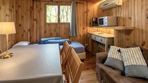 Une cabine équipée de deux lits, d’un bureau, d’un canapé et d’un appareil de climatisation.