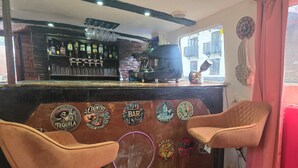 En bar med disk der viser forskellige flasker alkohol og et udvalg af barstole.