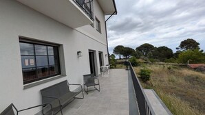 A building with a balcony, outdoor seating, and a view of trees and a fence. - Villa Da Vele - Between Volcano and the sea (Nicolosi)