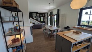 A spacious kitchen with a dining area, wooden flooring, and a staircase leading to another level. - Villa Da Vele - Between Volcano and the sea (Nicolosi)
