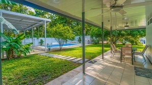A covered outdoor area with a pool, seating, and a lawn. - Uvita vacation rental with private pool, rancho lounge, and lush garden just minutes from the beach. (Uvita)