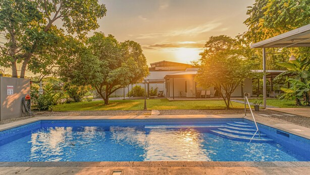 A swimming pool with a clear view of the surrounding area, including a building and trees. - Uvita vacation rental with private pool, rancho lounge, and lush garden just minutes from the beach. (Uvita)