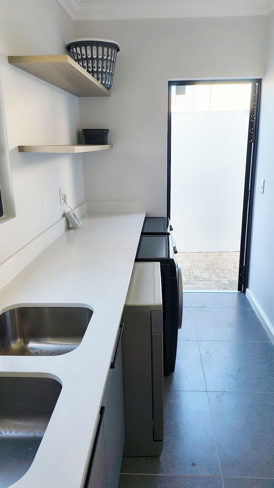 A modern kitchen with a dishwasher, a sink, and a window.