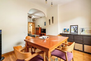 Ein Essbereich mit einem Holztisch und Stühlen, einem Fernseher und Bildern an der Wand.