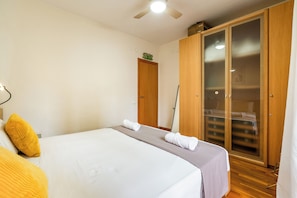 A bedroom with a bed, a wardrobe, and a ceiling fan. - Poble Sec Flat · 2 Balconies · A/C · 4 Guests · Near Montjuïc (Barcelona)