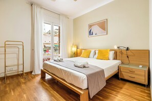 A hotel room with a bed, bedside table, and a view of the outside. - Poble Sec Flat · 2 Balconies · A/C · 4 Guests · Near Montjuïc (Barcelona)