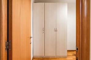 Ein Zimmer mit Holzschrank, Tür und Holzboden.