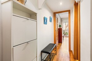 A hallway with a bench, a wardrobe, and a door leading to a balcony. - Poble Sec Flat · 2 Balconies · A/C · 4 Guests · Near Montjuïc (Barcelona)
