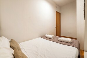 Ein Hotelzimmer mit einem Bett, Kissen und einer ordentlich bezogenen Bettdecke.