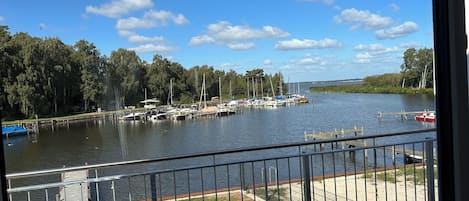 Un port de plaisance avec des bateaux amarrés, une zone herbeuse et un ciel dégagé.