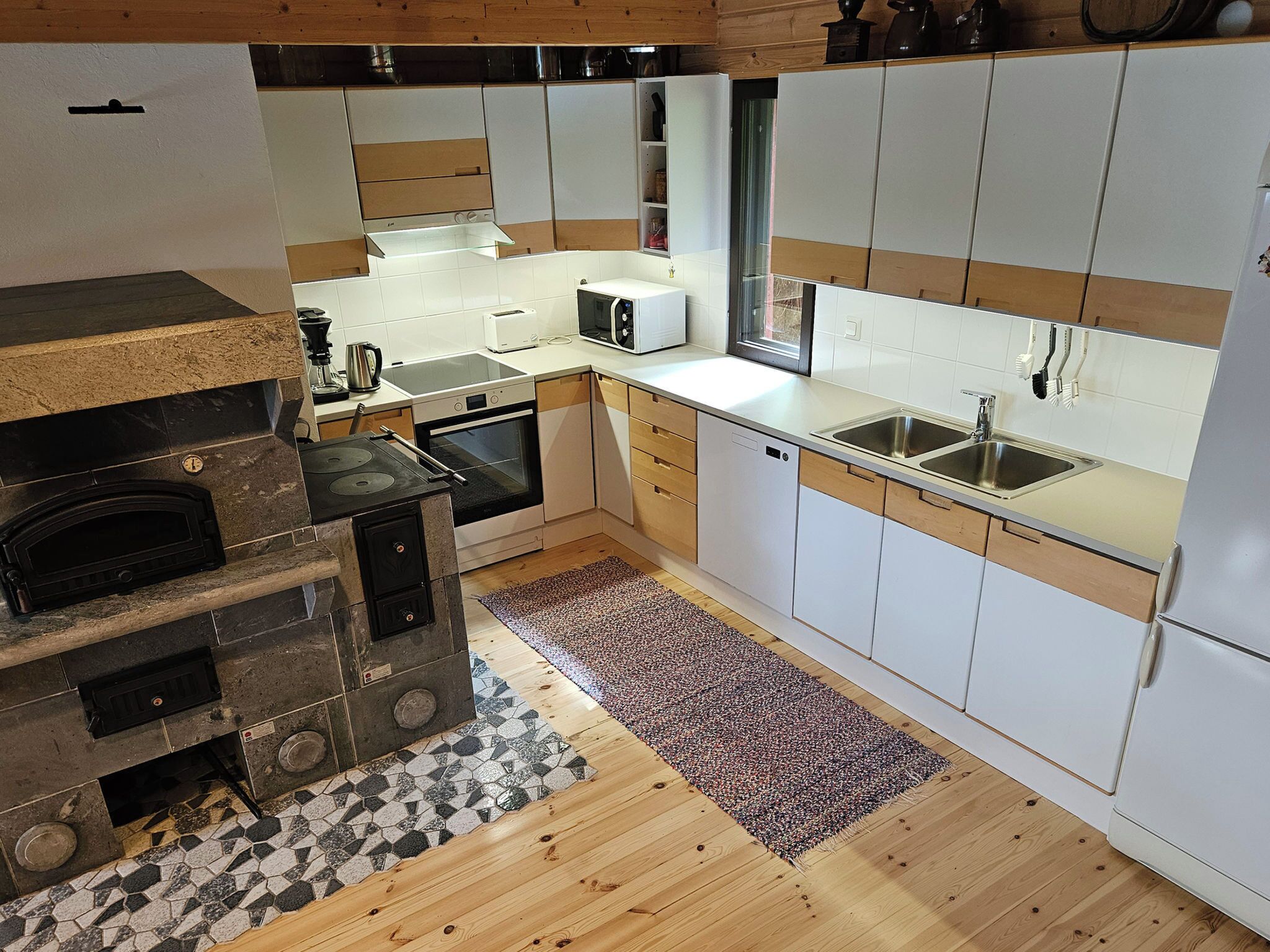Una cocina compacta con estufa, horno, microondas y pileta.