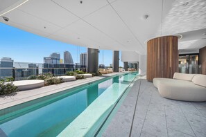 Une piscine sur le toit offrant une vue sur la ville, une architecture moderne et un espace détente.