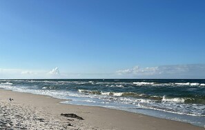 A beach with waves, a clear sky, and a distant cloud formation. - Lovely home in Kolczewo with WiFi (Kolczewo)