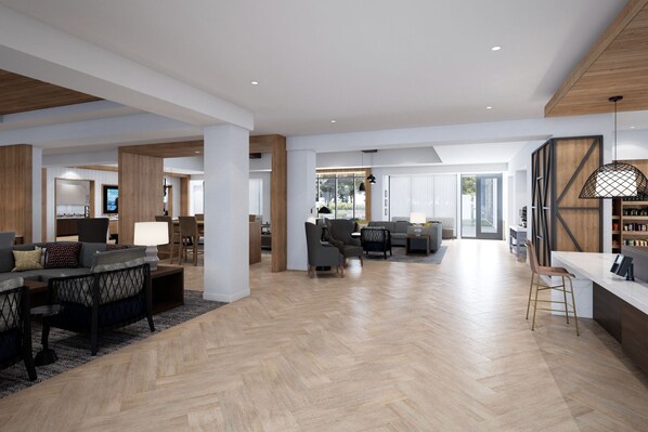 A spacious living area with a herringbone floor, a dining area with a table and chairs, and a kitchen visible in the background.
