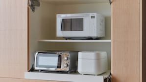 A kitchen with a microwave on the upper shelf and a toaster on the lower shelf. - ATUY ISHIZAKI (Hakodate City)