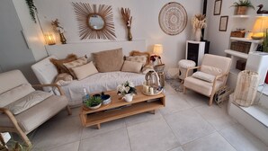 Una sala de estar acogedora con un sofá, un sillón y una mesa de centro con adornos.