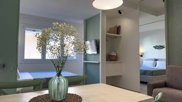 A dining area with a table, chairs, a vase with flowers, and pendant lights.