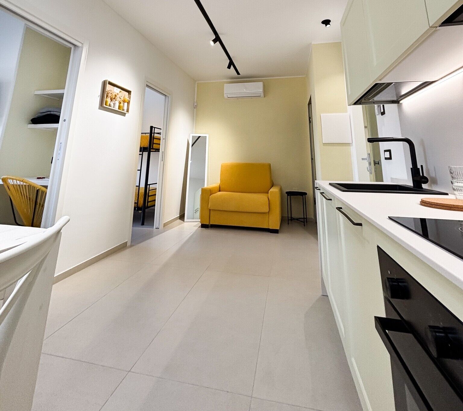 A compact kitchen with a sofa, a dining area, and a small table.