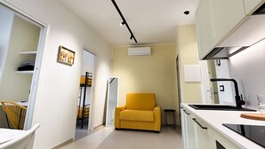 Una cocina compacta con sofá, comedor y una pequeña mesa.