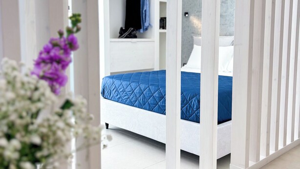 Un dormitorio moderno con cama, armario y espejo.