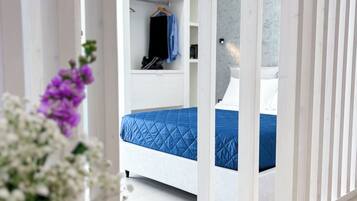 A modern bedroom with a bed, a wardrobe, and a mirror.