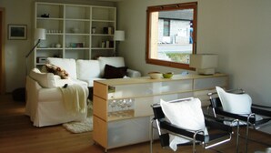 A modern living room with a sofa, a coffee table, a bookshelf, and a window with a view. - Tgèsa Muntaniala Stamm, (Sedrun), 198.02 by Interhome (Sedrun)