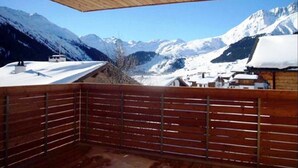 A wooden balcony with a view of snow-covered mountains. - Tgèsa Muntaniala Stamm, (Sedrun), 198.02 by Interhome (Sedrun)