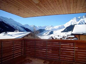 A wooden balcony with a view of snow-covered mountains. - Tgèsa Muntaniala Stamm, (Sedrun), 198.02 by Interhome (Sedrun)