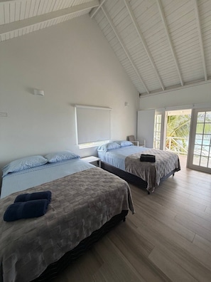 A room with two beds, a white ceiling, and a view of palm trees. - Beautiful North Coast Villa Blanchisseuse Trinidad (Blanchisseuse)