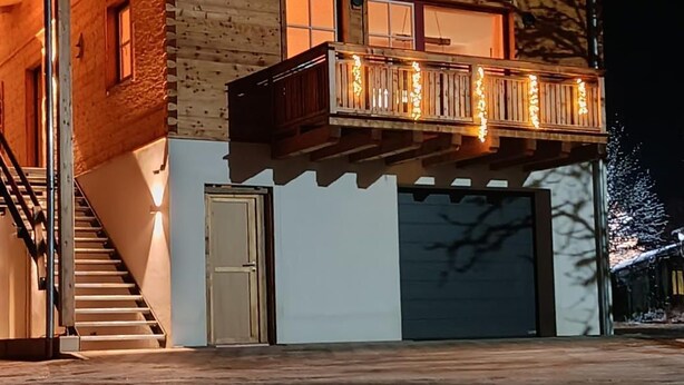 A two-story wooden cabin with balconies, a staircase, and a garage. - Henriette Vacation Rental (Teisendorf)