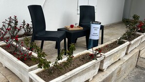Ein Außenbereich mit Sitzgelegenheiten für zwei Personen, einem Tisch und einem Schild für Raucher.