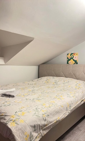 A bedroom with a bed, a headboard, a painting on the wall, and a towel on the bed. - Gorgeous apartment close to the sea with private beach (Antalya)