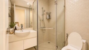 A modern bathroom with a glass-enclosed shower, a white sink, and a toilet. - Tranquil 2-bedroom condo with AC in Thành phố Hồ Chí Minh (Thành phố Hồ Chí Minh)
