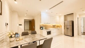 A modern kitchen with a marble countertop, stainless steel appliances, and a dining area with a marble table and chairs. - Tranquil 2-bedroom condo with AC in Thành phố Hồ Chí Minh (Thành phố Hồ Chí Minh)